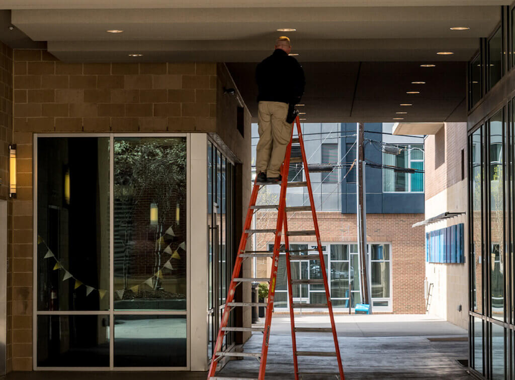 Electrician working outside on ladder